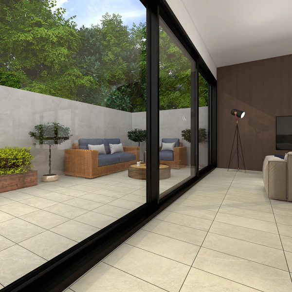 Large format beige porcelain floor tile extending from an indoor living area to an outdoor patio with wicker furniture. Flexstone tile.