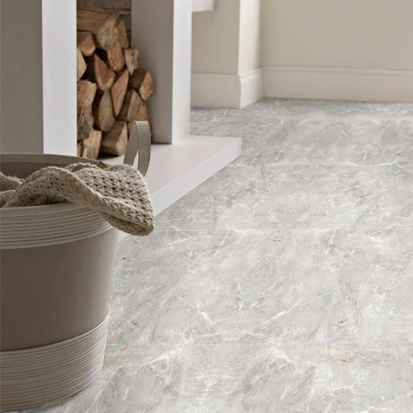 Olympia Pearl marble-look large format floor tiles in a cozy living room with a white fireplace and firewood storage, for a luxury look.