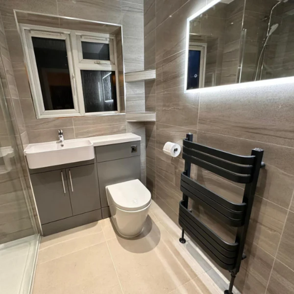 Modern shower room with large format Stonetech Wall & Floor Tile in a natural taupe stone-look on both walls and floor.