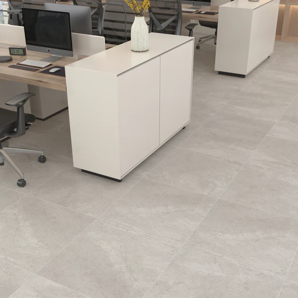 Modern office floor with large format Texas Wall & Floor Tile in a light grey concrete-look finish, creating a minimalist commercial space.