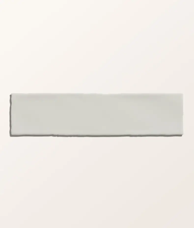 Carter Milk 7.5x30cm ceramic tiles with a handmade-look ripple texture and glossy, creamy white finish in a close-up photo.