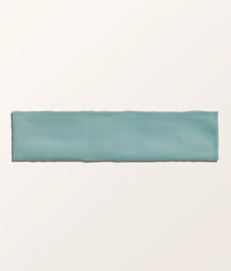 Carter Mint 7.5x30cm ceramic tiles with a handmade-look ripple texture and glossy, pale mint green finish in a close-up photo.