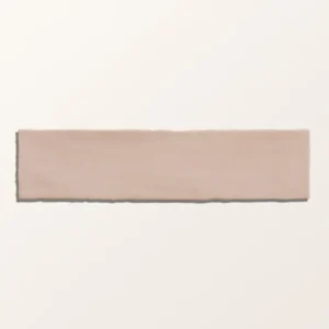 Carter Rose 7.5x30cm ceramic tiles with a handmade-look ripple texture and glossy, pale rose/pink finish in a close-up photo.