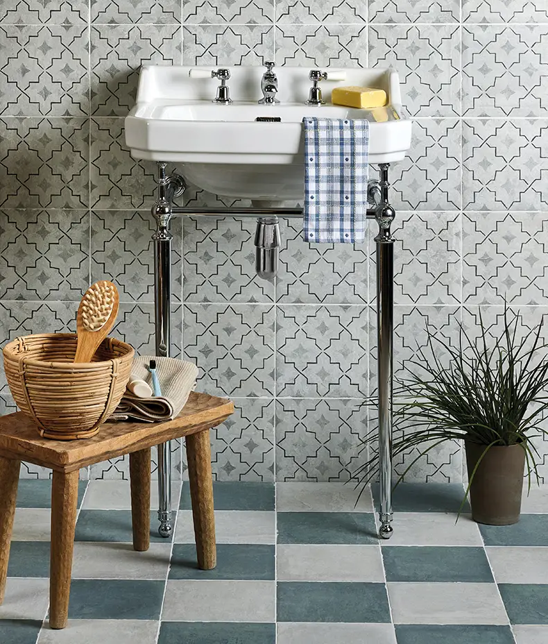 Cuba Porcelain Como 20x20cm tiles with a grey star/quatrefoil geometric pattern used as a wall feature behind a traditional washbasin in a bathroom.