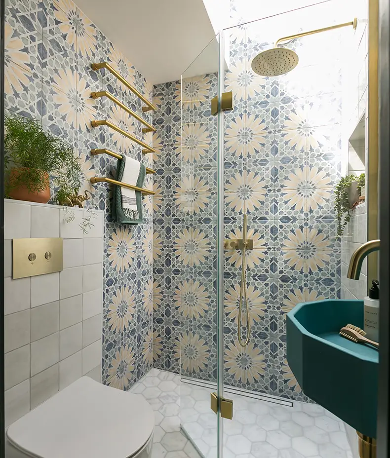 Cuba Porcelain Marla 20x20cm tiles creating a navy blue, cream, and ochre floral geometric patterned feature wall in a stylish shower room.