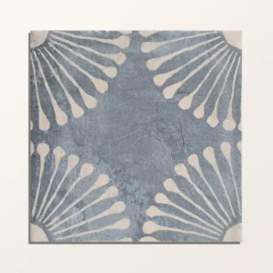Vedado Indigo 20x20cm porcelain tile with a distressed dark blue finish and a white shell/fan pattern on the top and bottom edges.