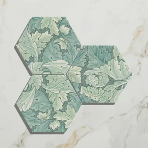 Folly Porcelain Moss Matt 20x23cm hexagonal tiles (three pieces) with a detailed green, sage, and white leaf/acanthus pattern on white marble.