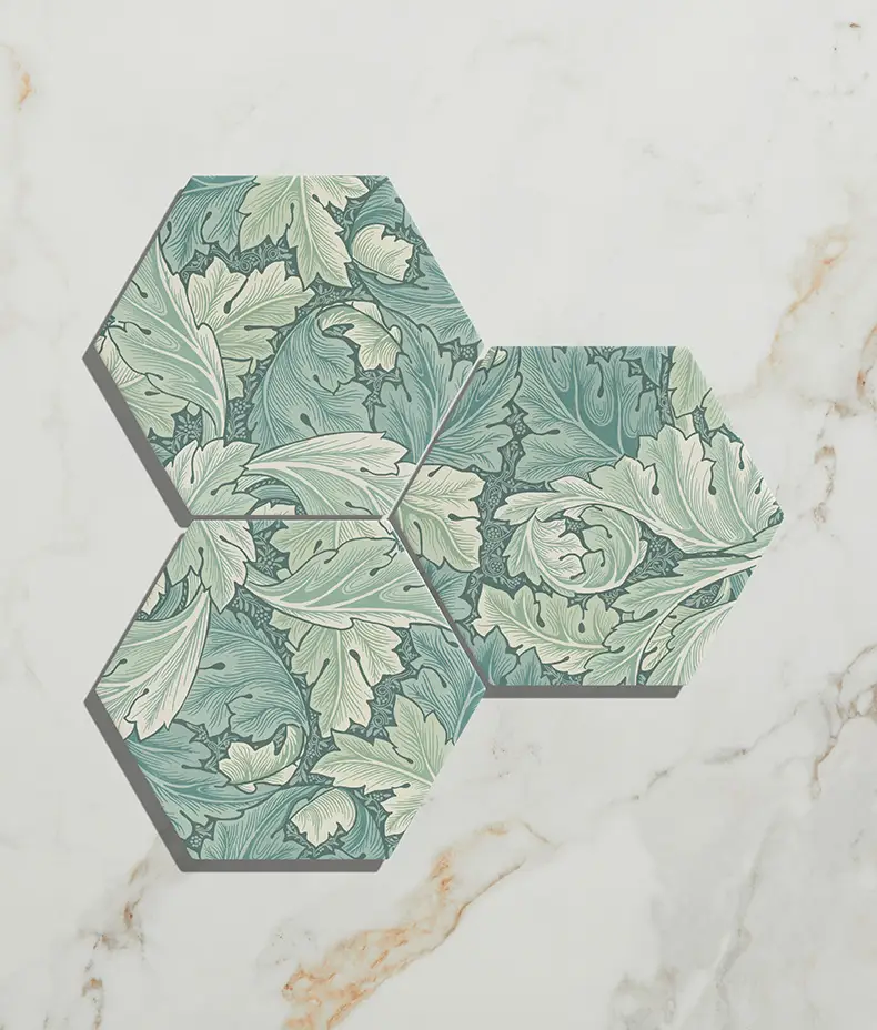 Folly Porcelain Moss Matt 20x23cm hexagonal tiles (three pieces) with a detailed green, sage, and white leaf/acanthus pattern on white marble.