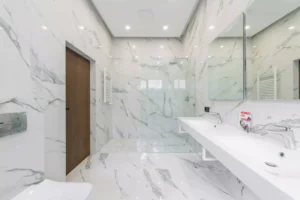 Modern UK bathroom featuring large format marble-effect porcelain tiles on the walls and floor with a seamless finish.